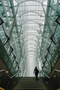 Stunning vertical shot of a modern atrium with a person ascending the staircase in Toronto's iconic Brookfield Place.
